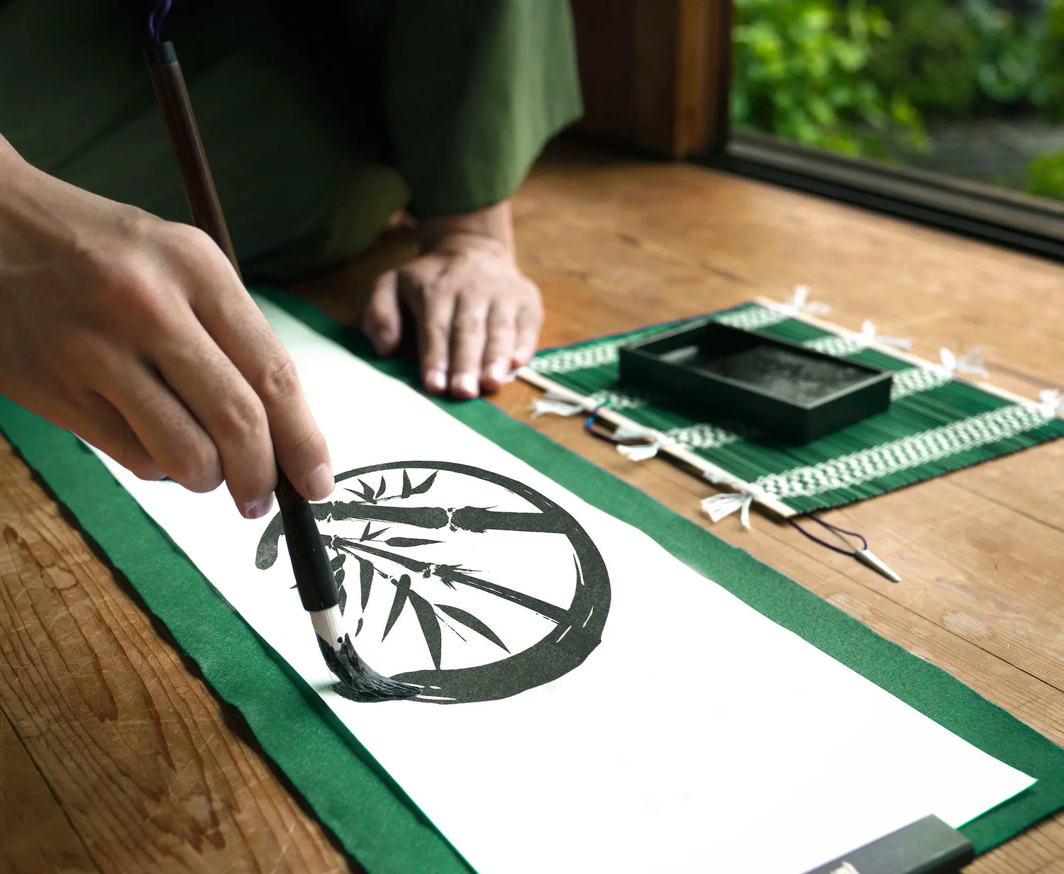 An Asian artist painting the Zenboo logo in traditional calligraphy, creating an elegant and artistic design.